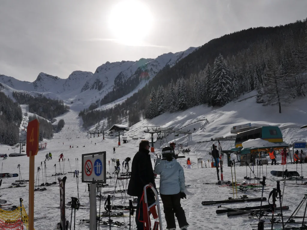 Blick über abgestellte Ski auf das Tal.